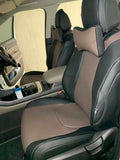Black and brown Kia Carnival front seat covers fitted in the vehicle
