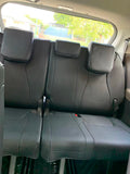 Black seat covers on the third-row bench of an 8-seat Kia Carnival
