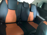 Black and orange covers on the Kia Carnival third-row bench seats